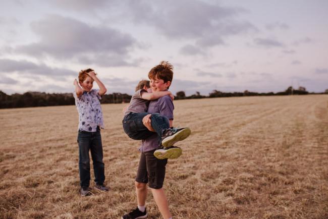 Brother spinning with his younger brother during golden hour family photography session at Perry's Paddock Perth