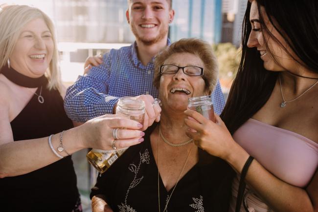 20181202-DSC_2618 Nonna being given drinks by her daughter and two grandchildren during Perth events photography session at The Bell Tower Perth