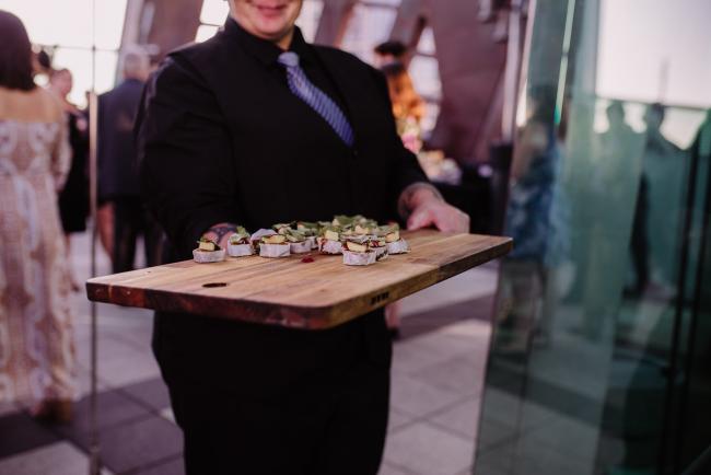 20181202-DSC_2646 Waiter holding out food during Perth events photography session at The Bell Tower Perth
