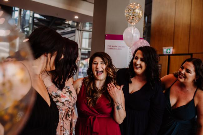 20181202-DSC_2816 Woman laughing with her bridesmaids in the foyer during Perth events photography session at The Bell Tower Perth