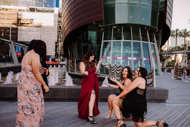 20181202-DSC_2967 Two women on their knees in front of another woman who is laughing during Perth events photography session at The Bell Tower Perth