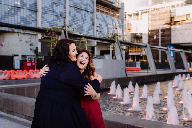 20181202-DSC_2972 Two women hugging during Perth events photography session at The Bell Tower Perth