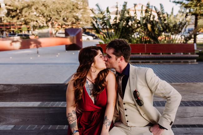 20181202-DSC_3038 Couple kissing on a wooden bench during Perth events photography session at The Bell Tower Perth