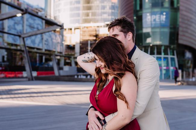 20181202-DSC_3102 Man hugging woman from behind as woman reaches back for him during Perth events photography session at The Bell Tower Perth