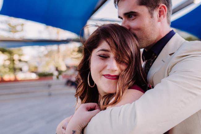 20181202-DSC_3127 Man hugging partner from behind as she smiles during Perth events photography session at The Bell Tower Perth
