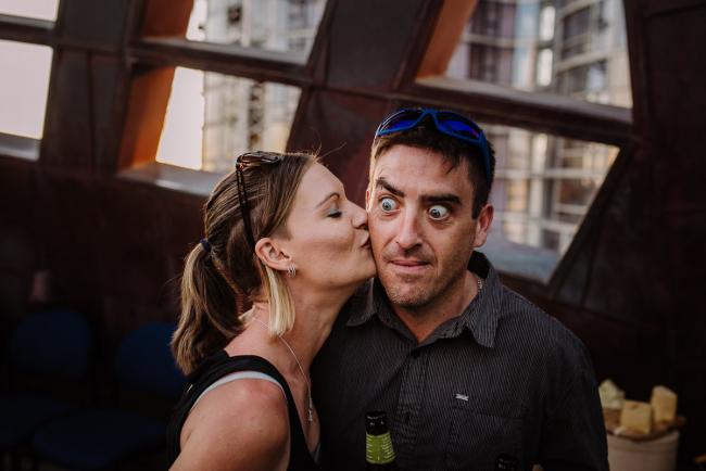 20181202-DSC_3350 Woman kissing a surprised man during Perth events photography session at The Bell Tower Perth