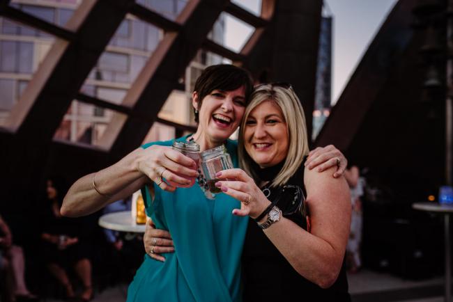 20181202-DSC_3510 Two women doing cheers during Perth events photography session at The Bell Tower Perth