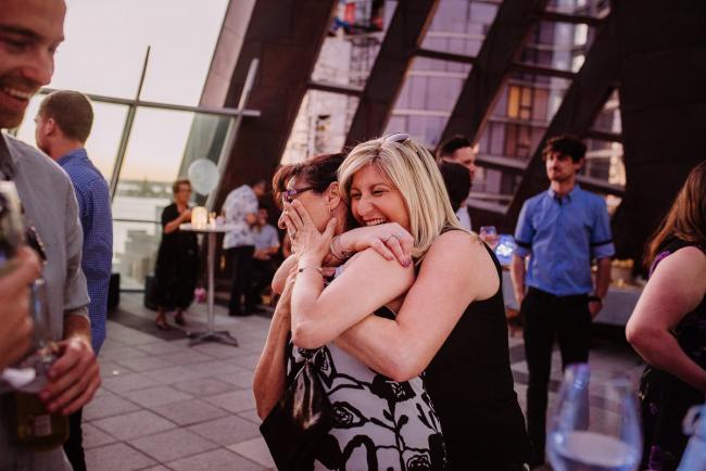 20181202-DSC_3605 Two women hugging and laughing during Perth events photography session at The Bell Tower Perth
