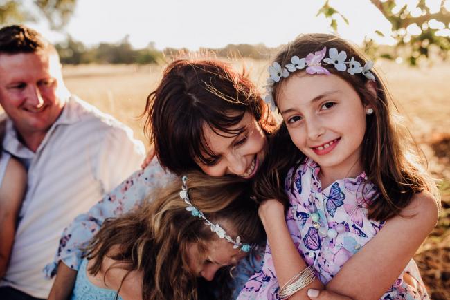 Mother hugging her two daughters and smiling during an extended family photography session at Perry's Paddock in Perth