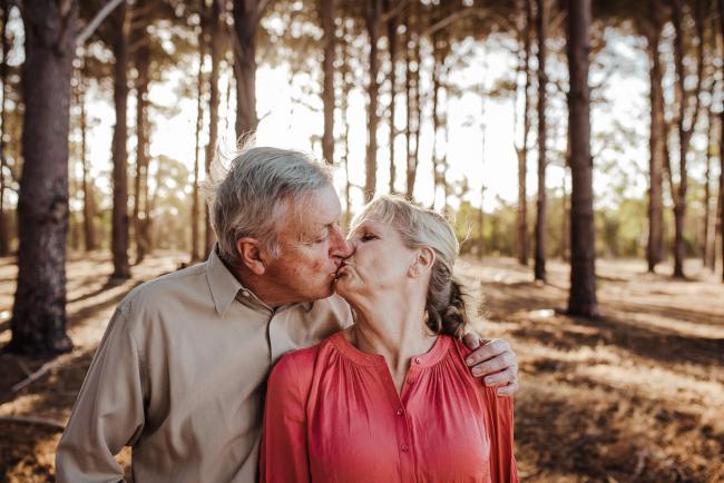Couple kissing during an extended family photography session at The Pines Wanneroo in Perth
