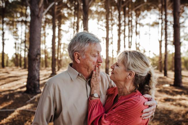 Woman touching the mouth of her partner during an extended family photography session at The Pines Wanneroo in Perth