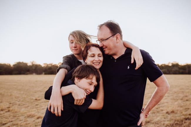 Family of 4 hugging their mother during an extended family photography session at Perry's Paddock in Perth