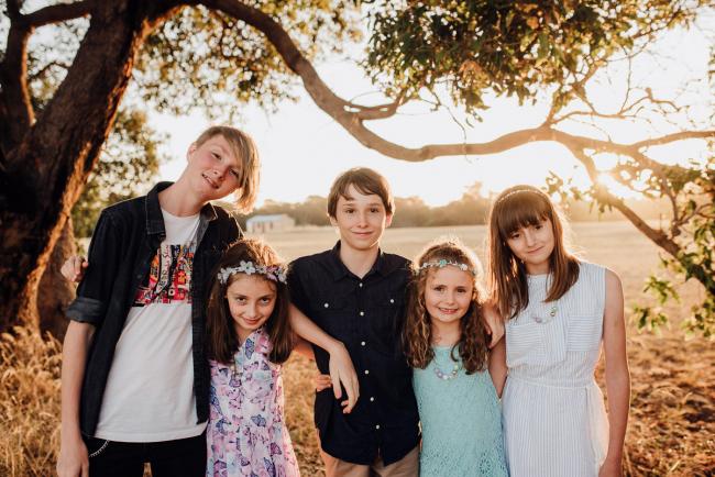 Cousins standing arm in arm during an extended family photography session at Perry's Paddock in Perth