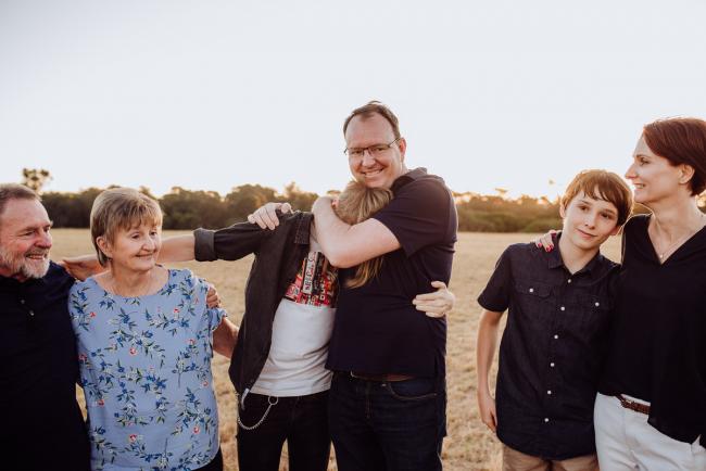 Father wrestling with his son's head during an extended family photography session at Perry's Paddock in Perth