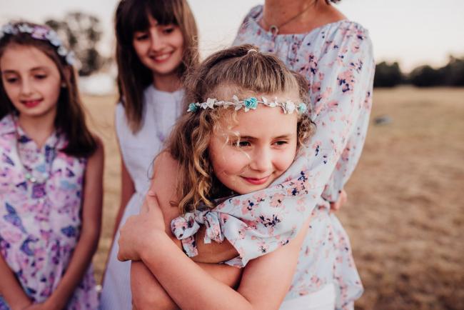 Little girl hugging her mothers arms during an extended family photography session at Perry's Paddock in Perth