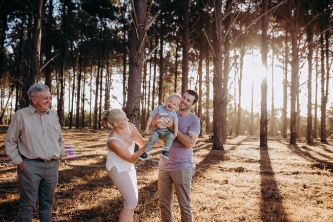 Father lifting his son into the air during an extended family photography session at The Pines Wanneroo in Perth