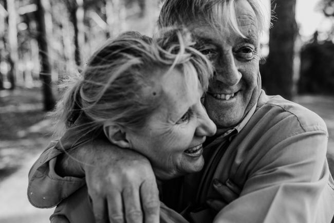 Black and white image of an older couple hugging during an extended family photography session at The Pines Wanneroo in Perth