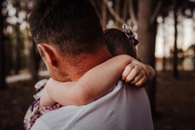 Daughter with arms wrapped around her father during an extended family photography session at The Pines Wanneroo in Perth