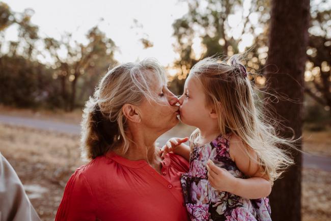 Grandmother kissing her granddaughter during an extended family photography session at The Pines Wanneroo in Perth