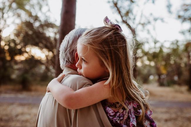 Little girl hugging her grandfather during an extended family photography session at The Pines Wanneroo in Perth