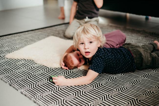 20180610-20180610-DSC_7592 Big brother laying on the floor with his new baby sister during a lifestyle newborn photography session in Perth
