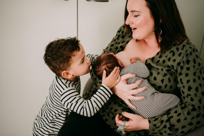 20180706-20180706-DSC_6201 New big brother kissing his baby brother who is being breastfed during a lifestyle newborn photography session in Perth