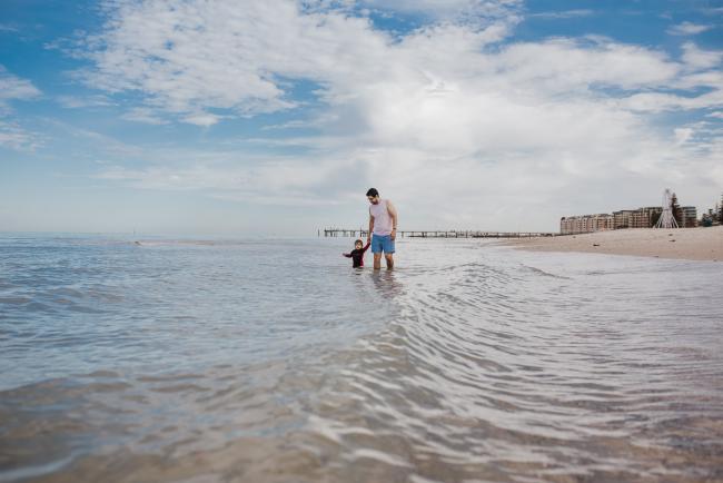 Father and son wading in the beach water with Perth family photographer