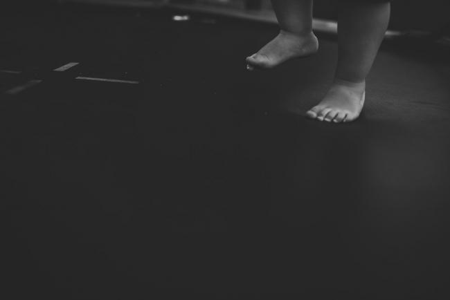 Black and white image of little boys feet jumping on the trampoline with Perth family photographer