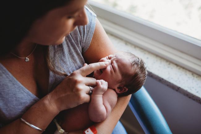 Mother touches new baby's nose during a Perth Fresh 48 photography session
