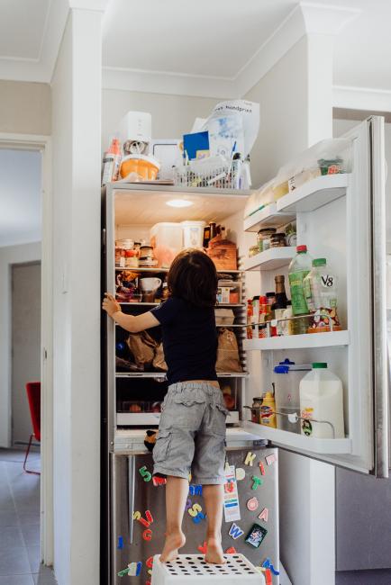 Little boy reaching into the fridge on a stool by Perth family photographer