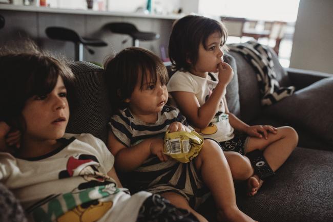 Three little boys sitting on the couch eating in their pyjamas with Perth family photographer