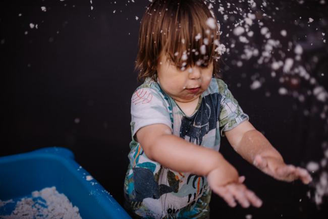 Little boy throwing sand with Perth family photographer