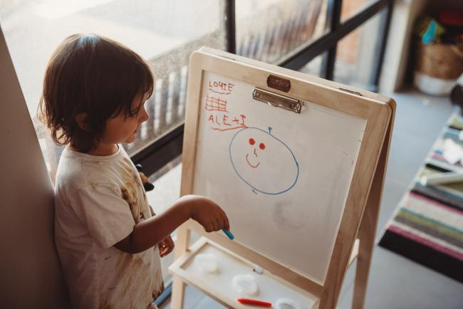Little boy drawing on an easel with Perth family photographer