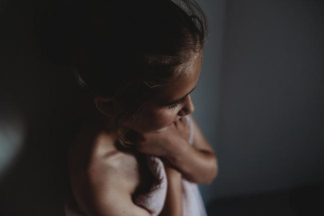 Girl standing with her towel around her in the shadows with Perth family photographer
