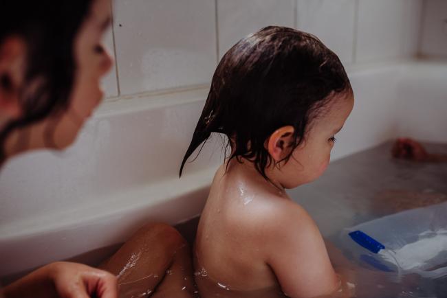 Little boy with wet hair in the bath with Perth family photographer