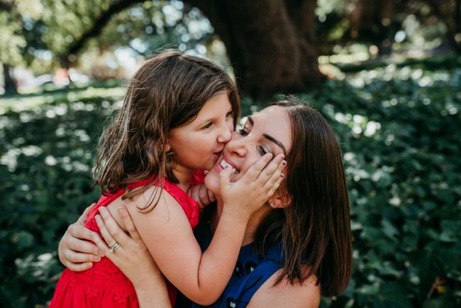 Family-Photographer-Perth-Hyde-Park-19-of-34 Little girl holding her mothers face and kissing her during a Perth family photography session at Hyde Park