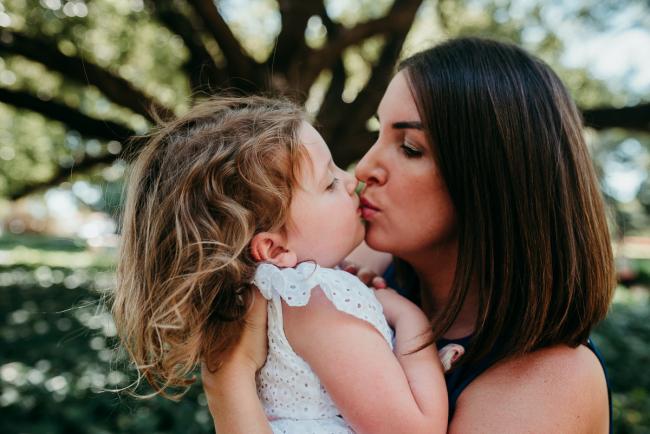 Mother and daughter kissing during a Perth family photography session at Hyde Park