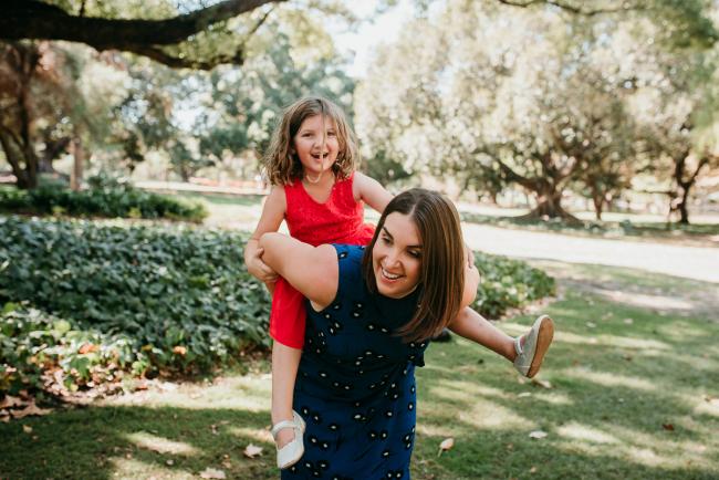 Family-Photographer-Perth-Hyde-Park-24-of-34 Little girl getting a piggy back from her mother during a Perth family photography session at Hyde Park