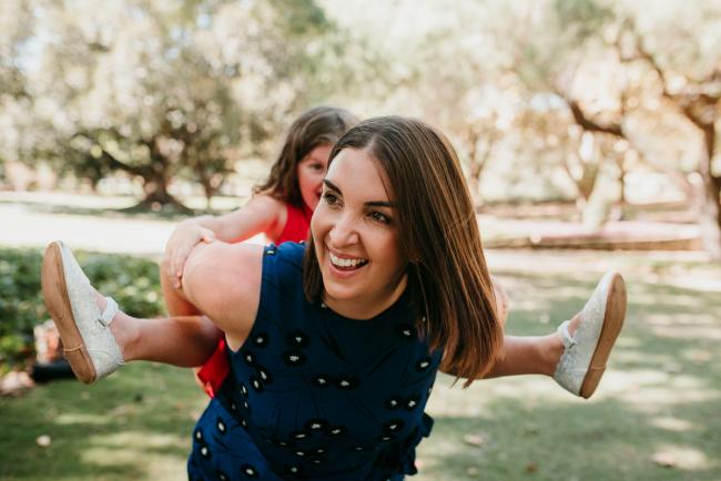 Family-Photographer-Perth-Hyde-Park-25-of-34 Little girl having a piggyback ride with her mother during a Perth family photography session at Hyde Park
