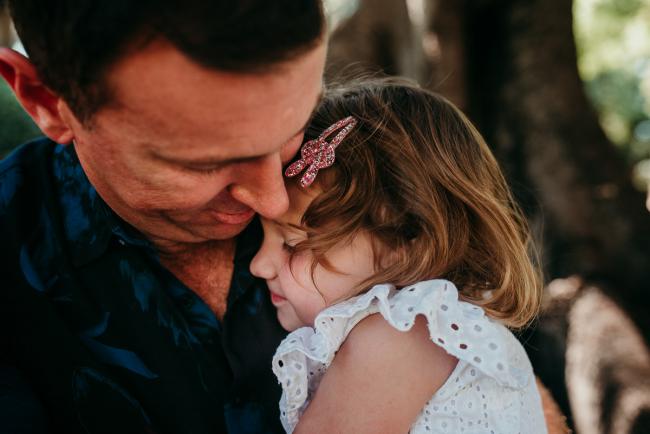Family-Photographer-Perth-Hyde-Park-3-of-34 Close up of little girl cuddling into her dad during a Perth family photography session at Hyde Park