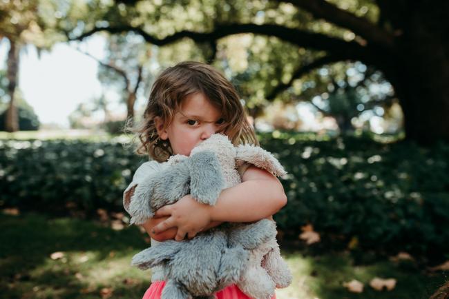 Family-Photographer-Perth-Hyde-Park-34-of-34 Little girl cuddling her bunnies and looking at the camera during a Perth family photography session at Hyde Park