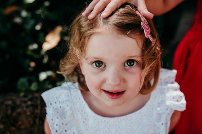 Family-Photographer-Perth-Hyde-Park-9-of-34 Close up of a little girl in a white dress during a Perth family photography session at Hyde Park
