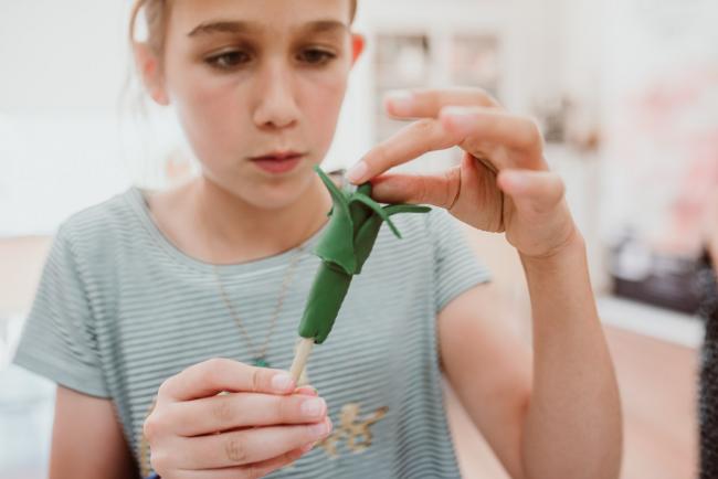 Family-Photography-Perth-16-of-25 Close up of girl creating with fondant during a Birthday party at Cakes Tinz 'n' Thingz with Perth family photographer
