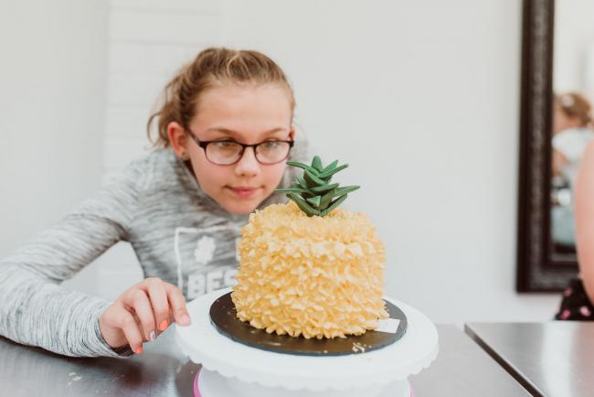 Family-Photography-Perth-21-of-25 Girl looking at a pineapple cake during a Birthday party at Cakes Tinz 'n' Thingz with Perth family photographer