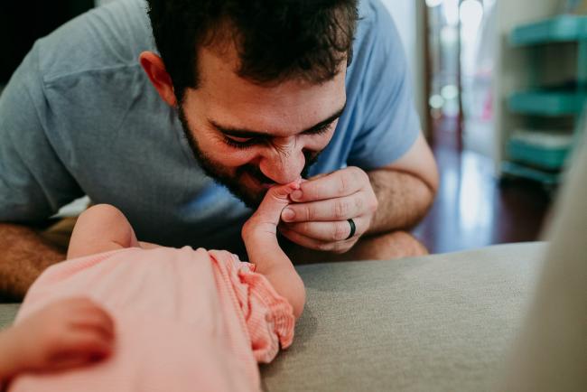 Dad smelling his new baby's feet during a Perth newborn lifestyle photography session