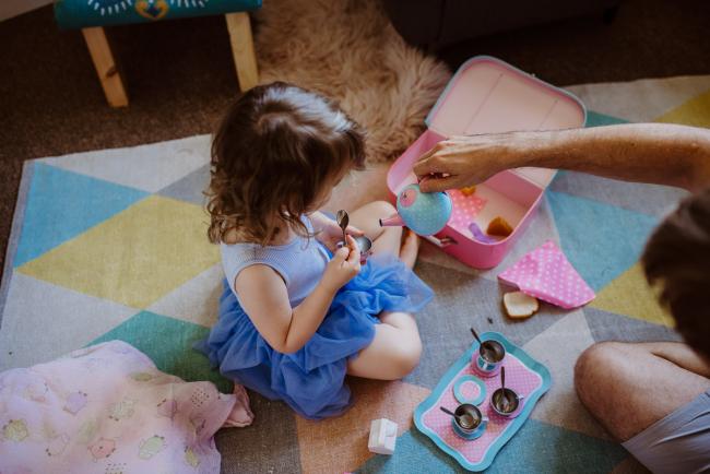 Top down image of father pouring pretend tea as he plays tea parties with his daughter during a Perth lifestyle Newborn photography session