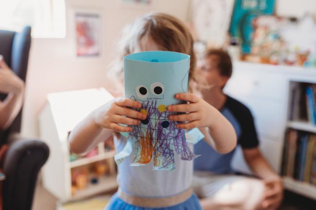 Little girl showing her artisic creation to the camera during a Perth lifestyle Newborn photography session