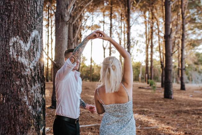 Perth-Couples-Photography-14-of-27 Couple in a dancing spin next to a tree with a love heart on it at The Pines Wanneroo during a Golden Hour Perth couples photography session