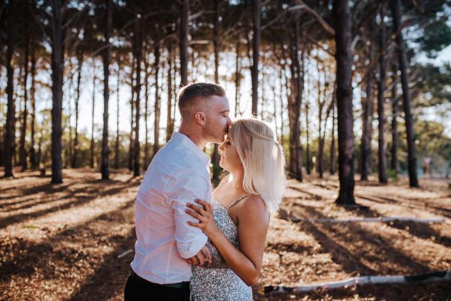 Man kissing his girlfriends forehead during a Perth couples photography session at The Pines in Wanneroo