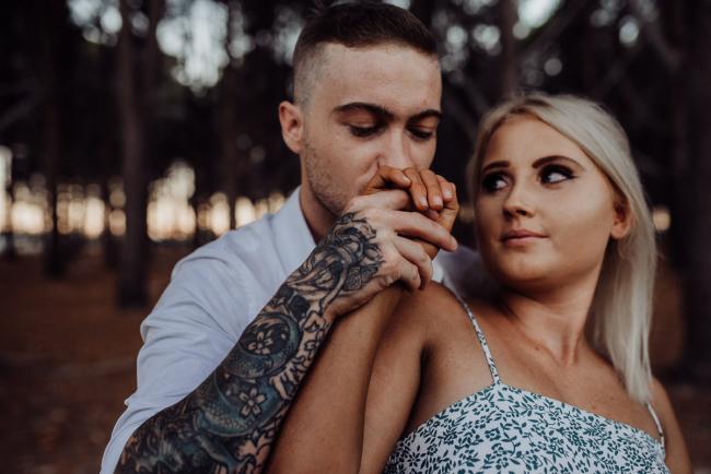 Perth-Couples-Photography-24-of-27 Man kissing his partners hand at The Pines Wanneroo during a Golden Hour Perth couples photography session